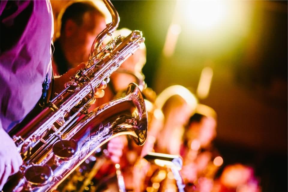A band’s saxophone section under warm stage lights